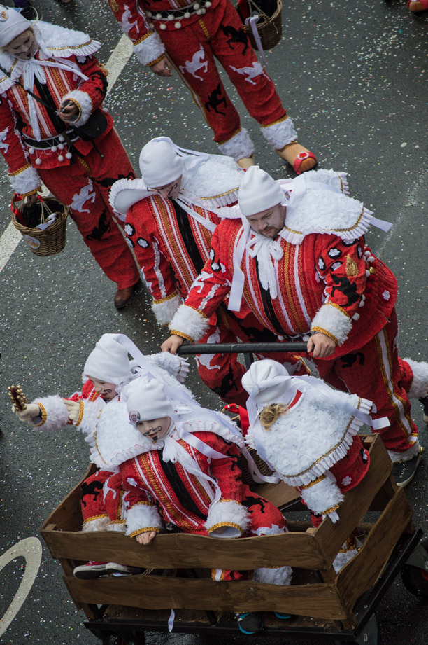 Red and white dancers and children in a cart